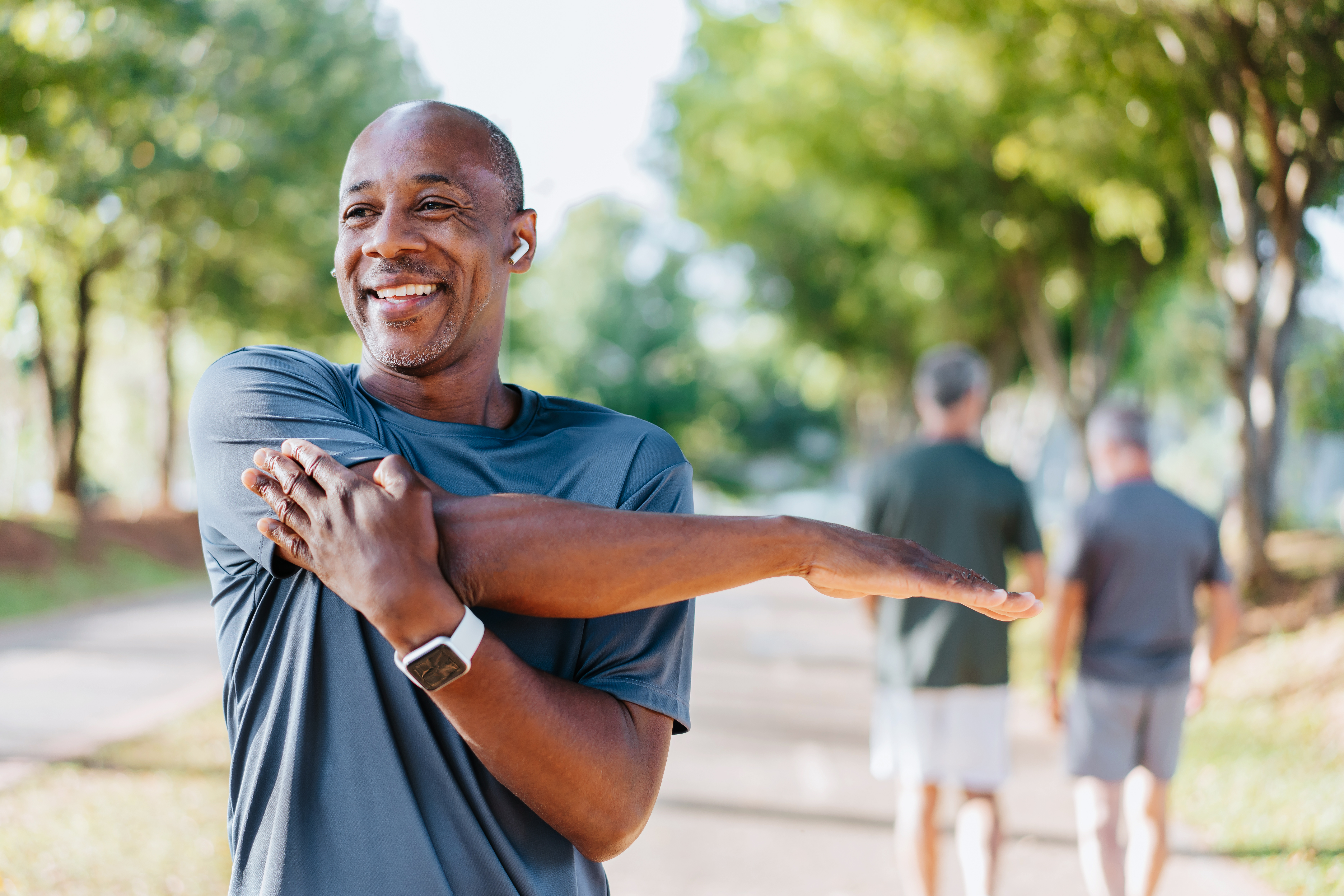 Man jogging and stretching his shoulder.