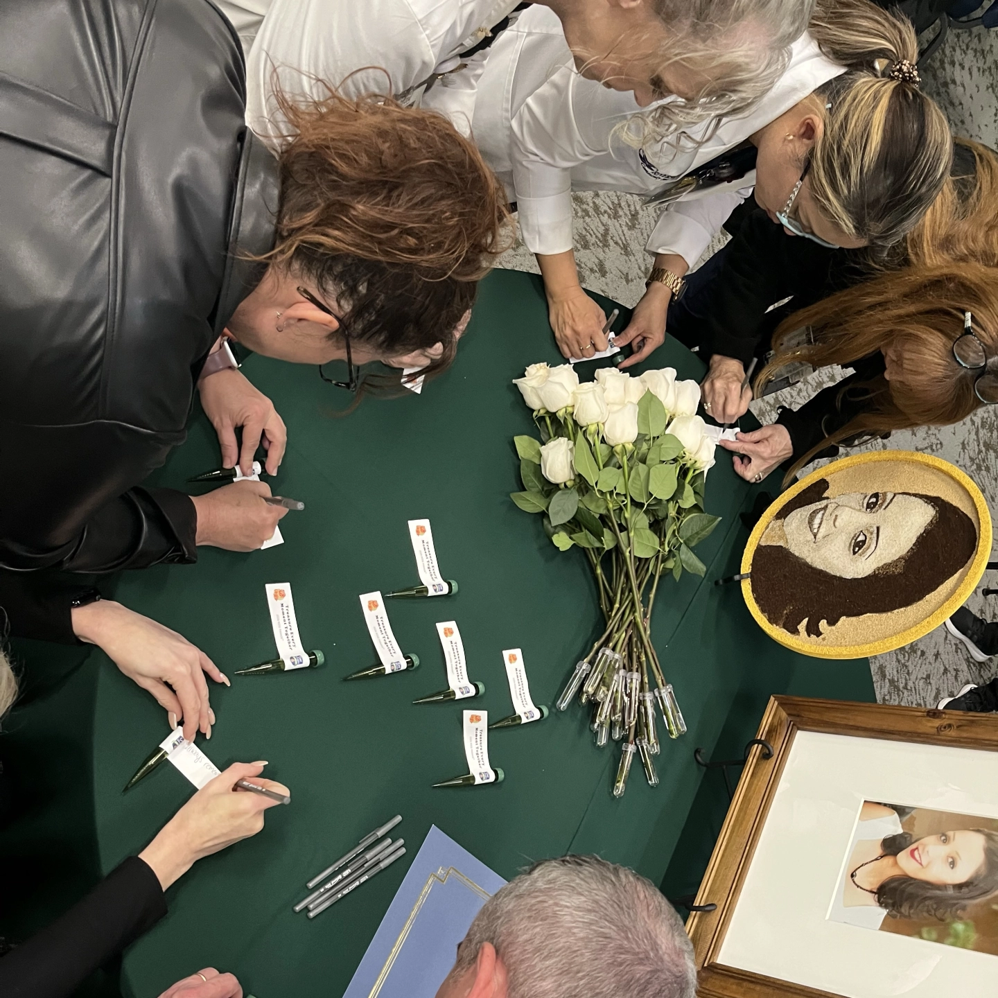 RCH colleagues writing messages on rose viles that will be placed on the float.