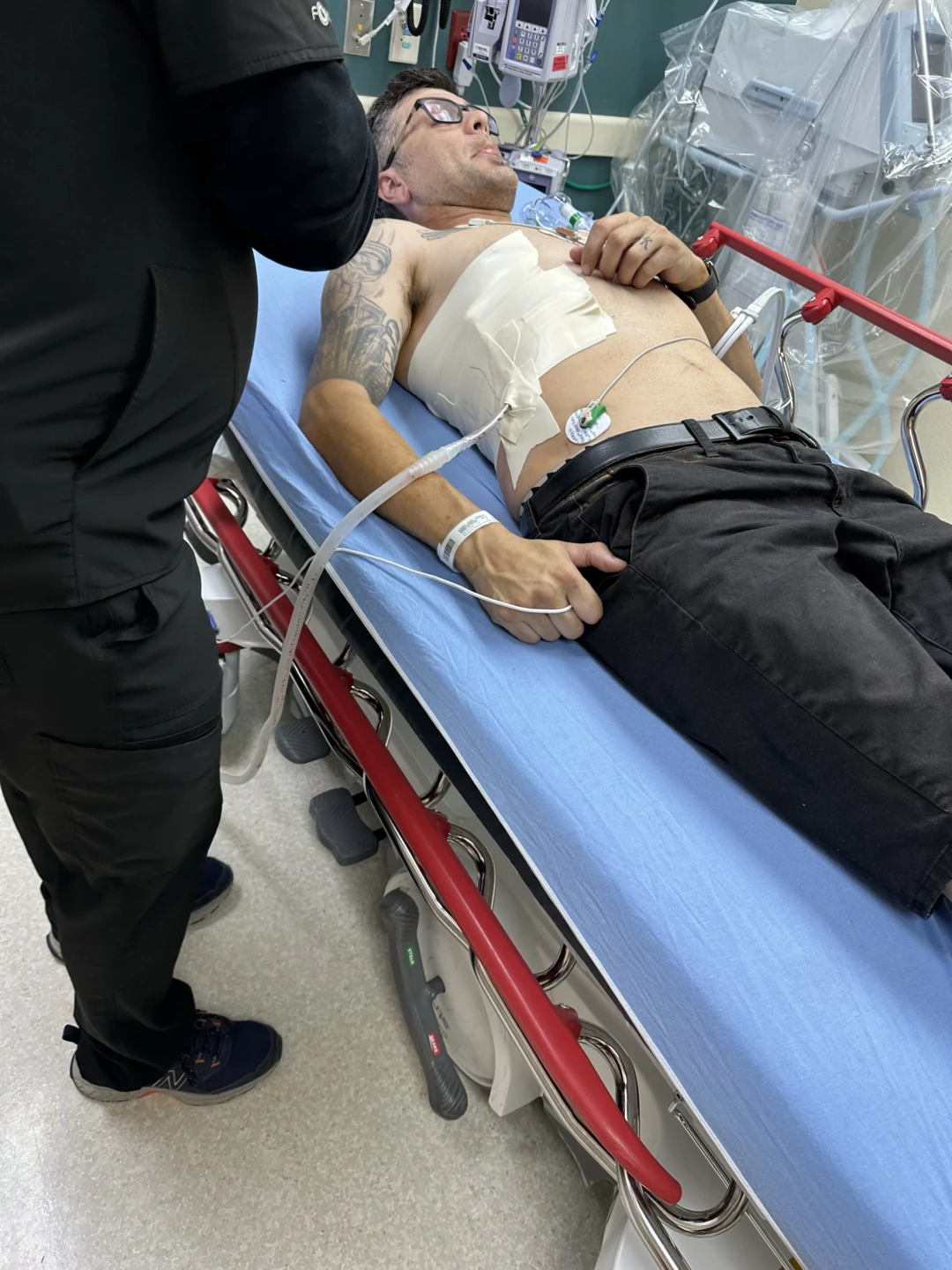 Kody laying down on a stretcher with bandages on his side