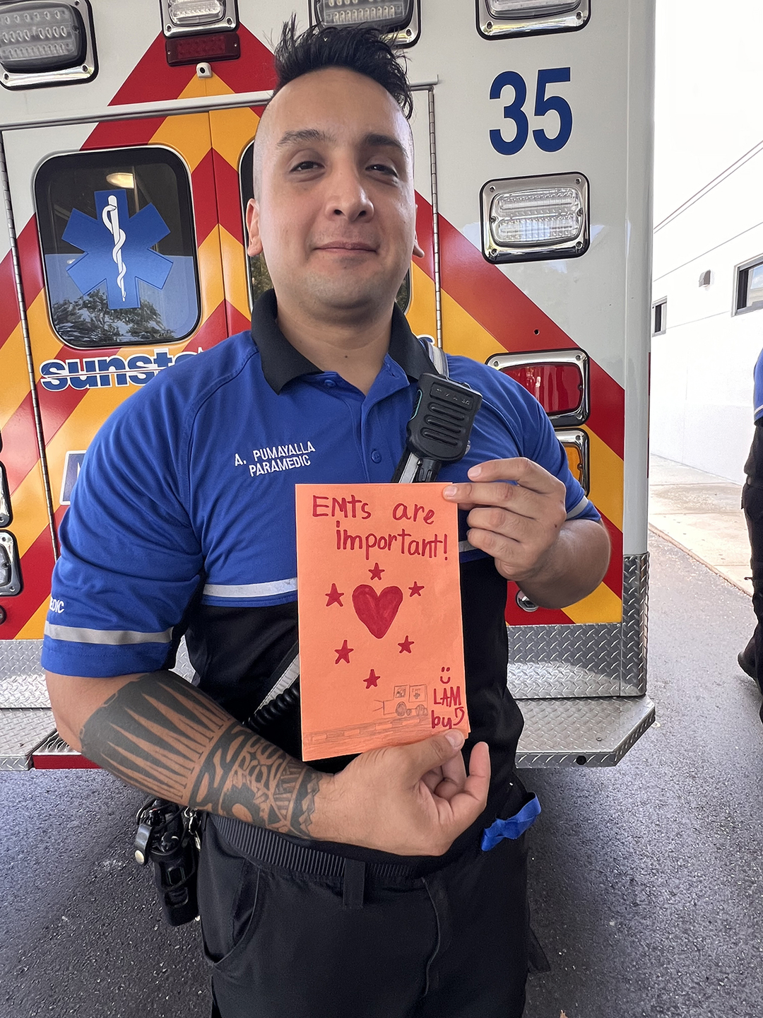 HCAFL EMS driver holds handmade greeting card he received.