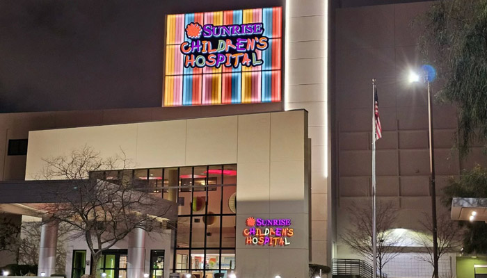 The front exterior of the Sunrise Children's Hospital at night.