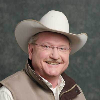 Lonnie smiles for the camera, wearing a cowboy hat.