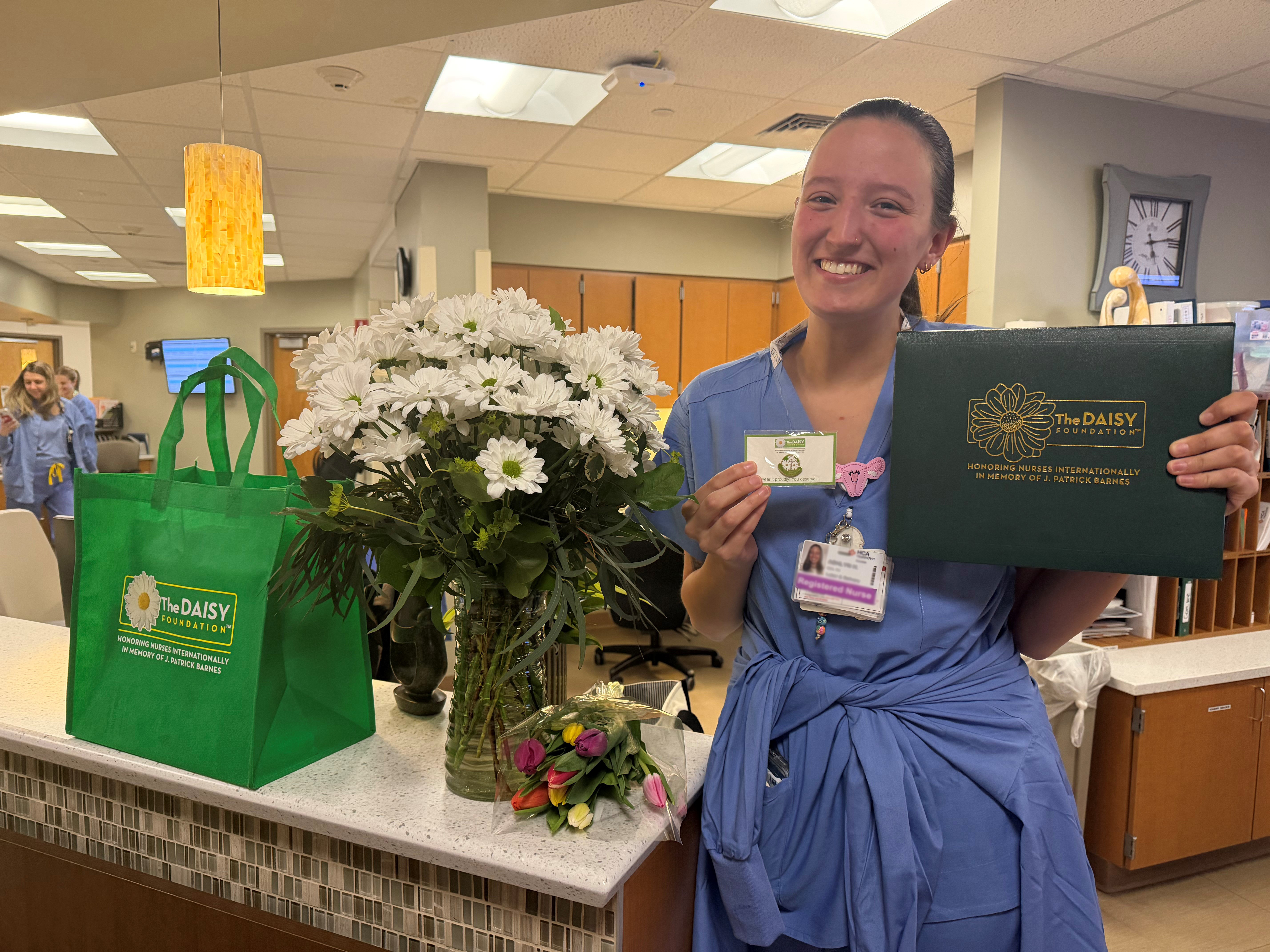 Ashlyn Holmes poses with the Daisy award inside the hospital.