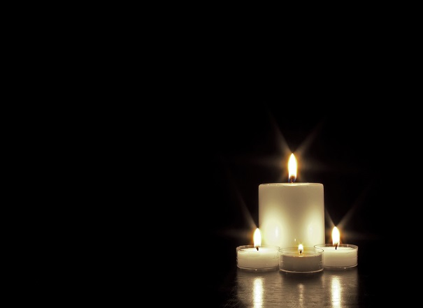 Four candles against black background.