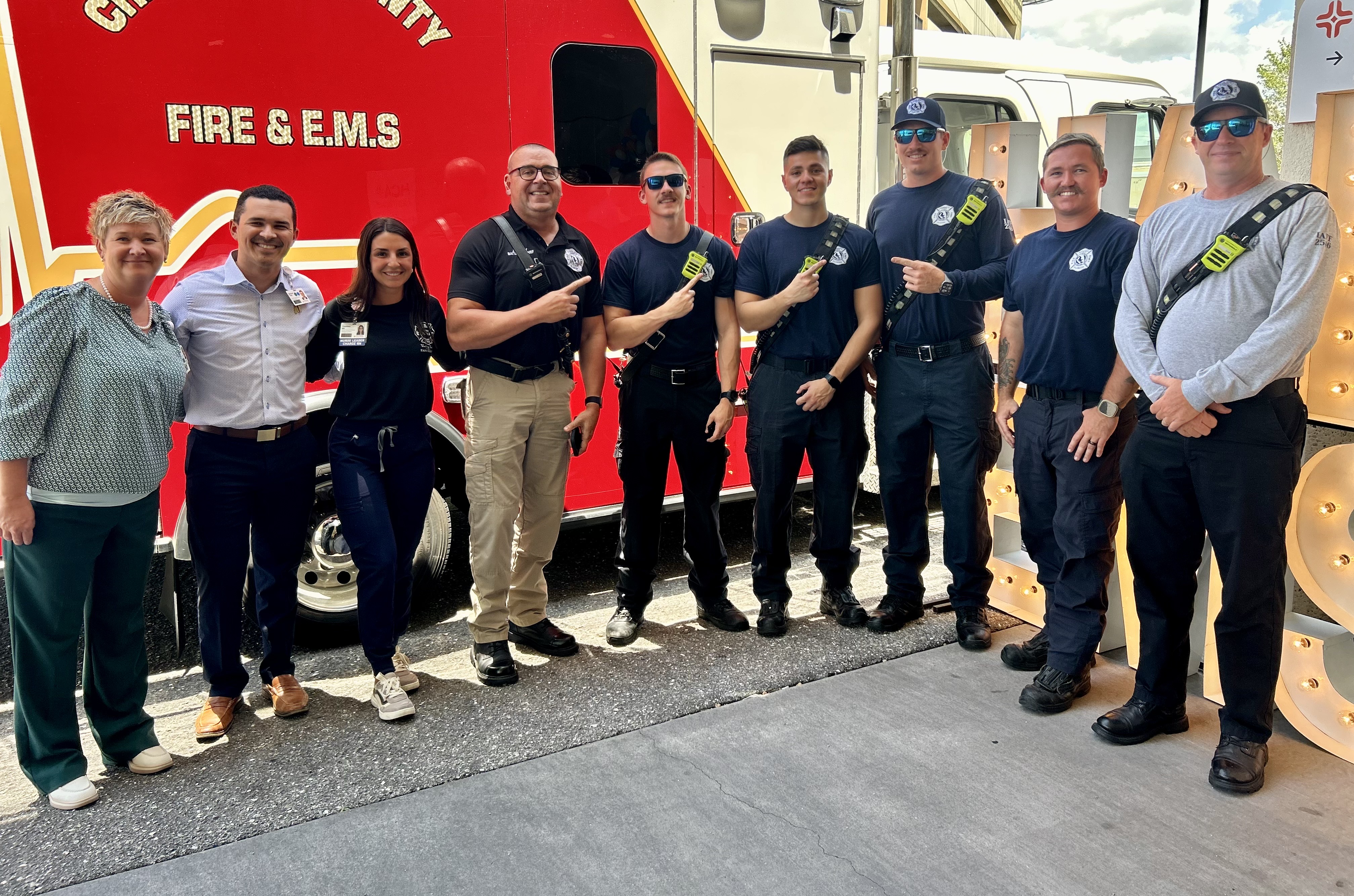 Fawcet Hospital and EMS and first responders pose in front of red fire truck.