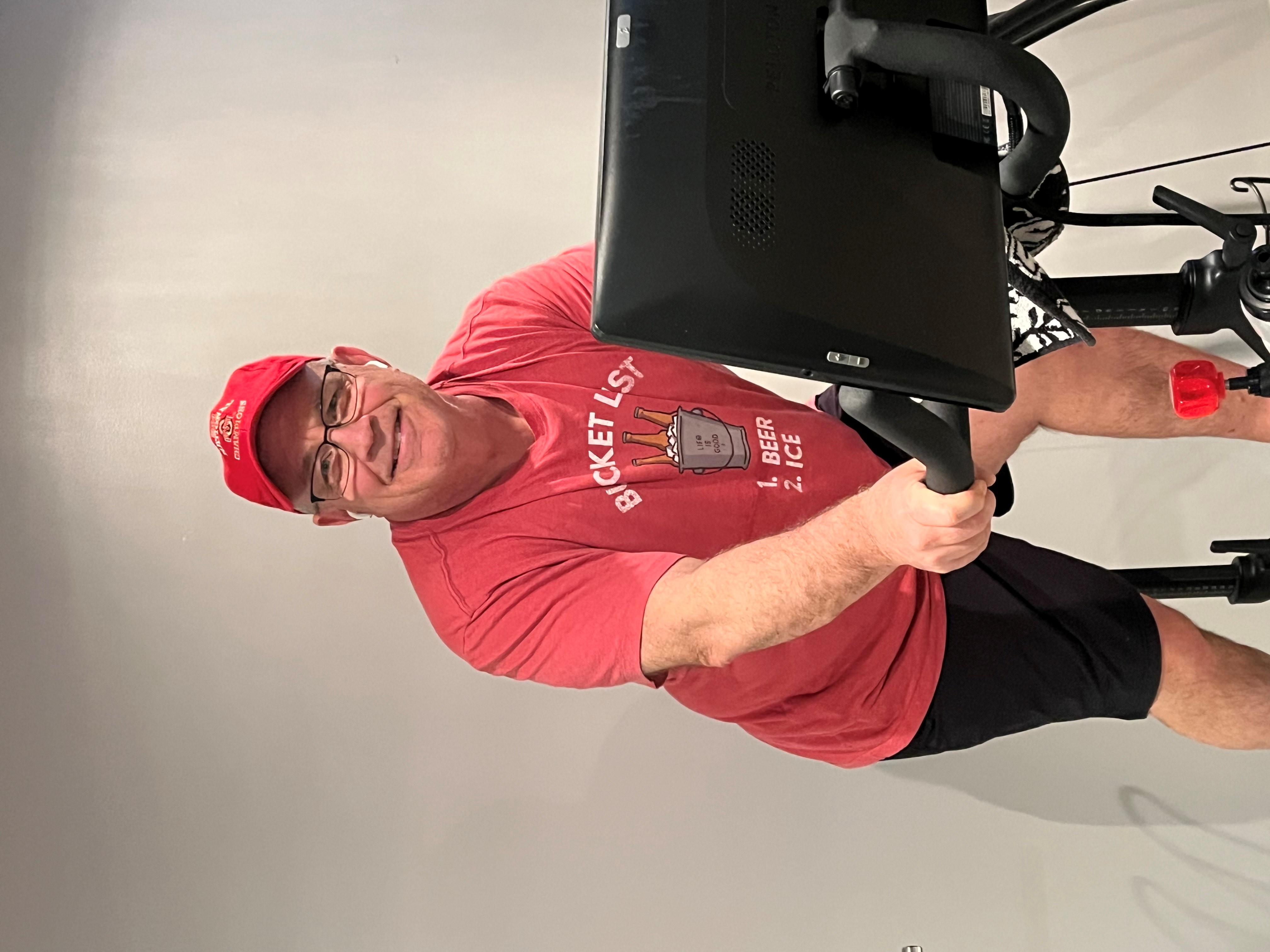 Robert Herold on a stationary bike, smiling.