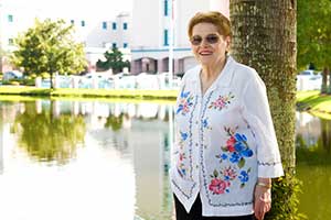 Lia Maita standing near a tree in front of a lake