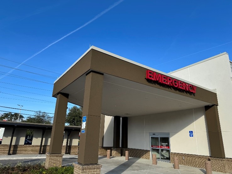 Merril Road ER entrence, roundabout driveway, brown awning against white building.