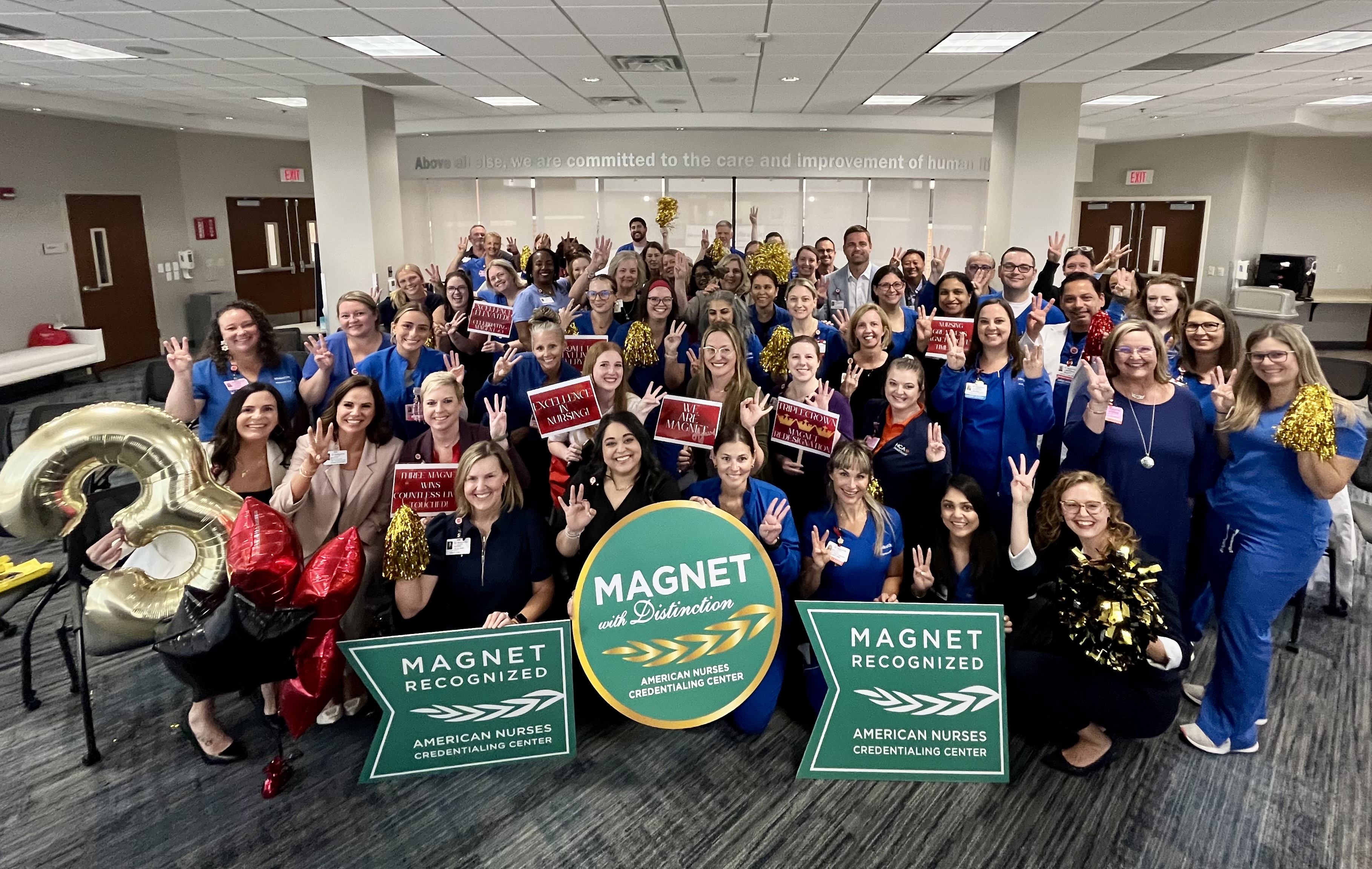 Medical City Lewisville staff posing in big group photo with magnet recognition award signs