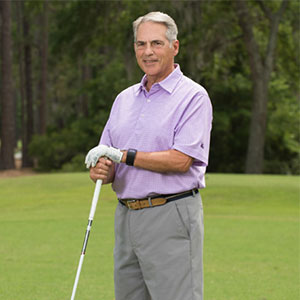 Joseph Grispo on a golf course holding a golf club.
