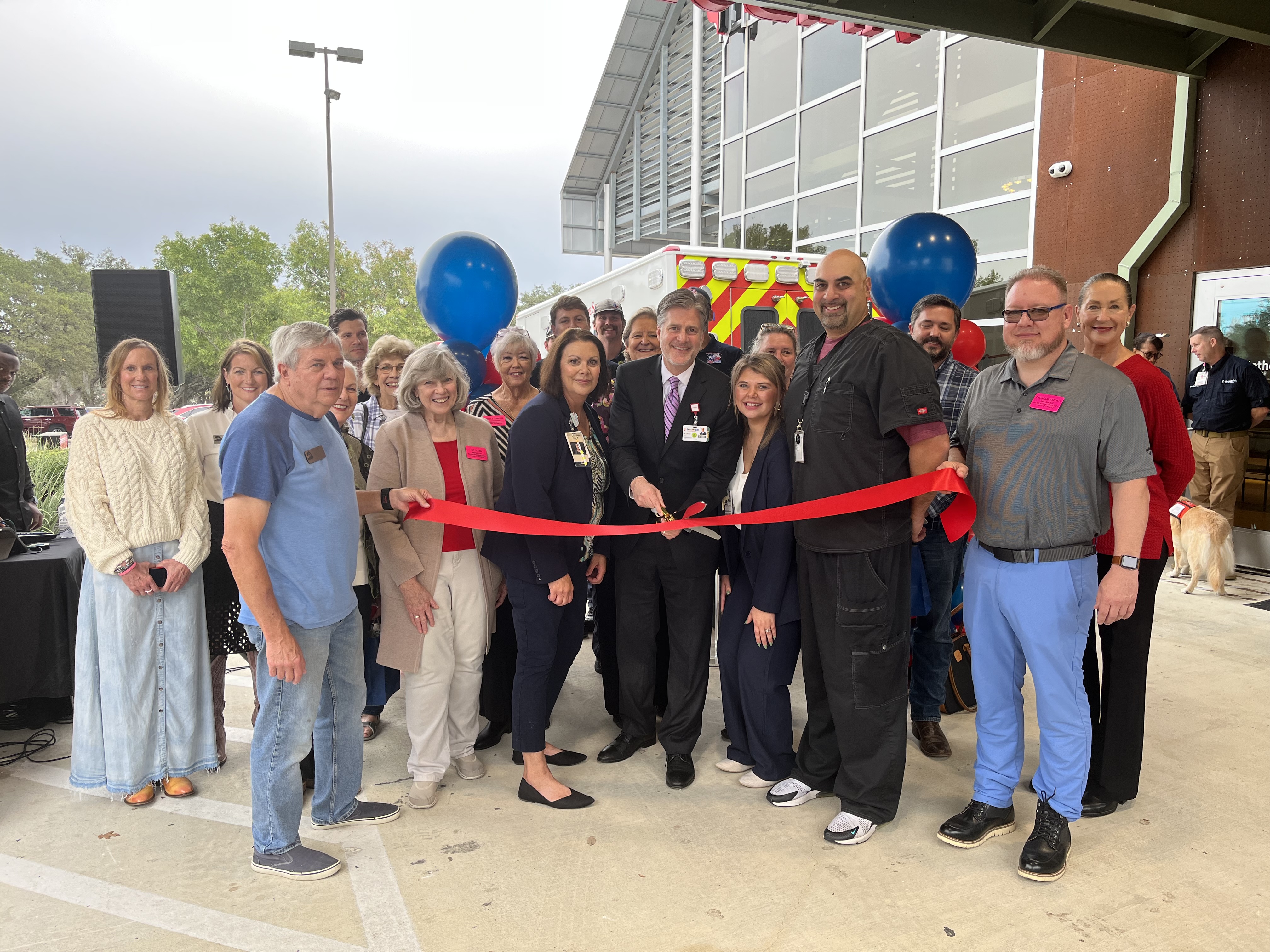 Staff cutting ribbon for opening of new freestanding emergency room.
