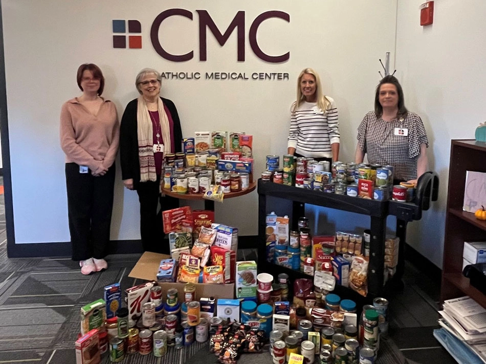 Colleagues from Catholic Medical Center gathered around donated food items.