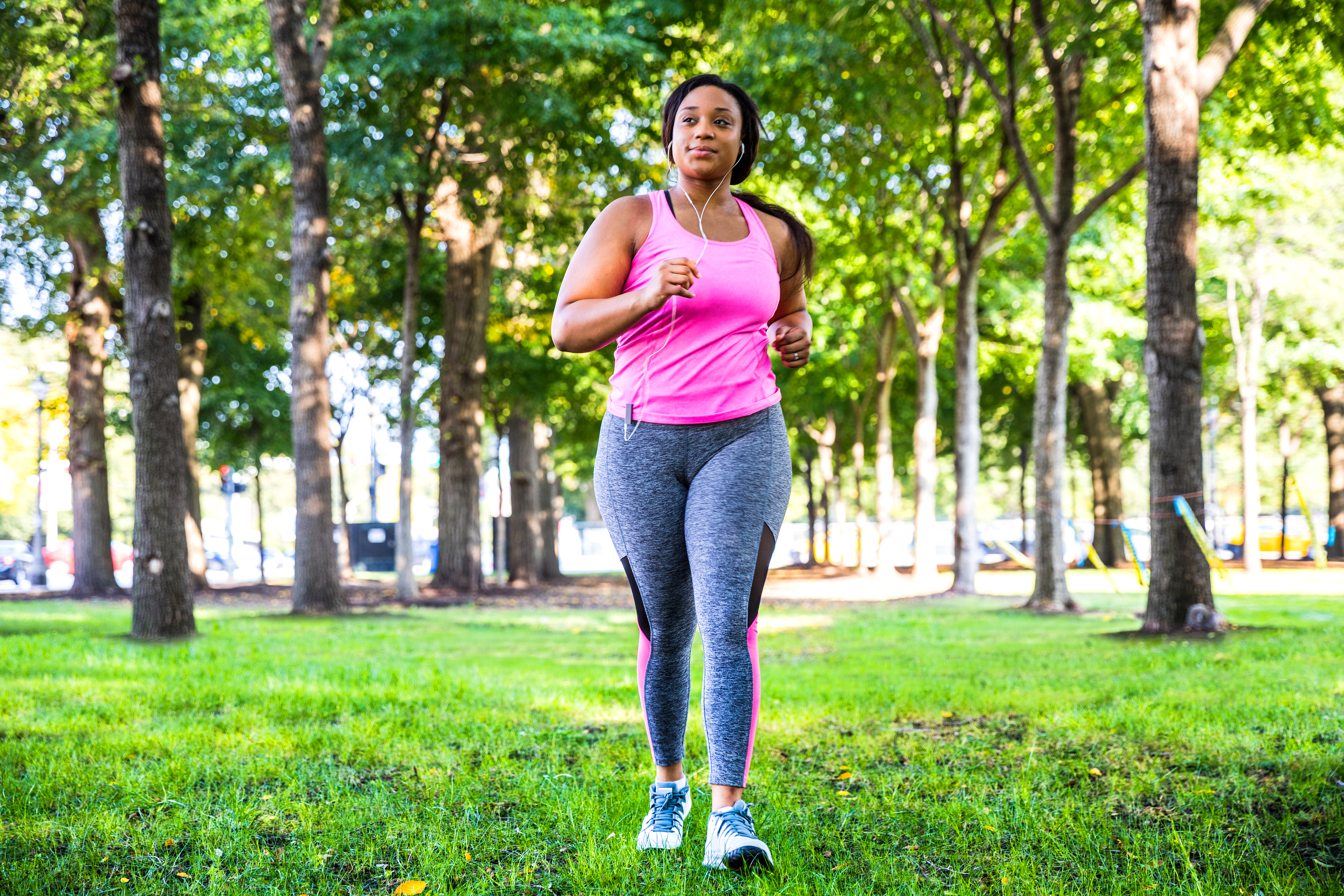 Plus size women jogging and exercising at the park and walking outdoor in the city streets in Chicago, United States