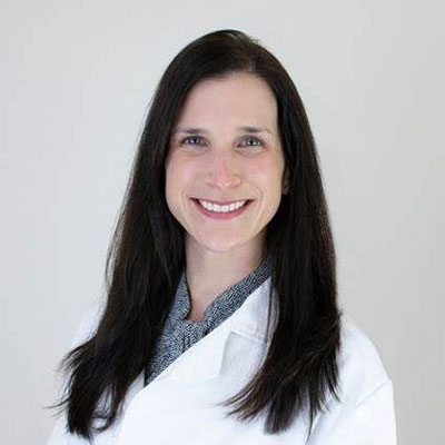 Dr. Miranda C. Norton smiles wearing a physician's jacket.