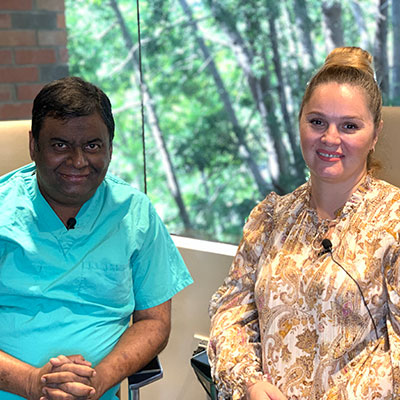 Dr. Saibal Kar and Elena Veytsman smile for the camera, while seated in front of a window.