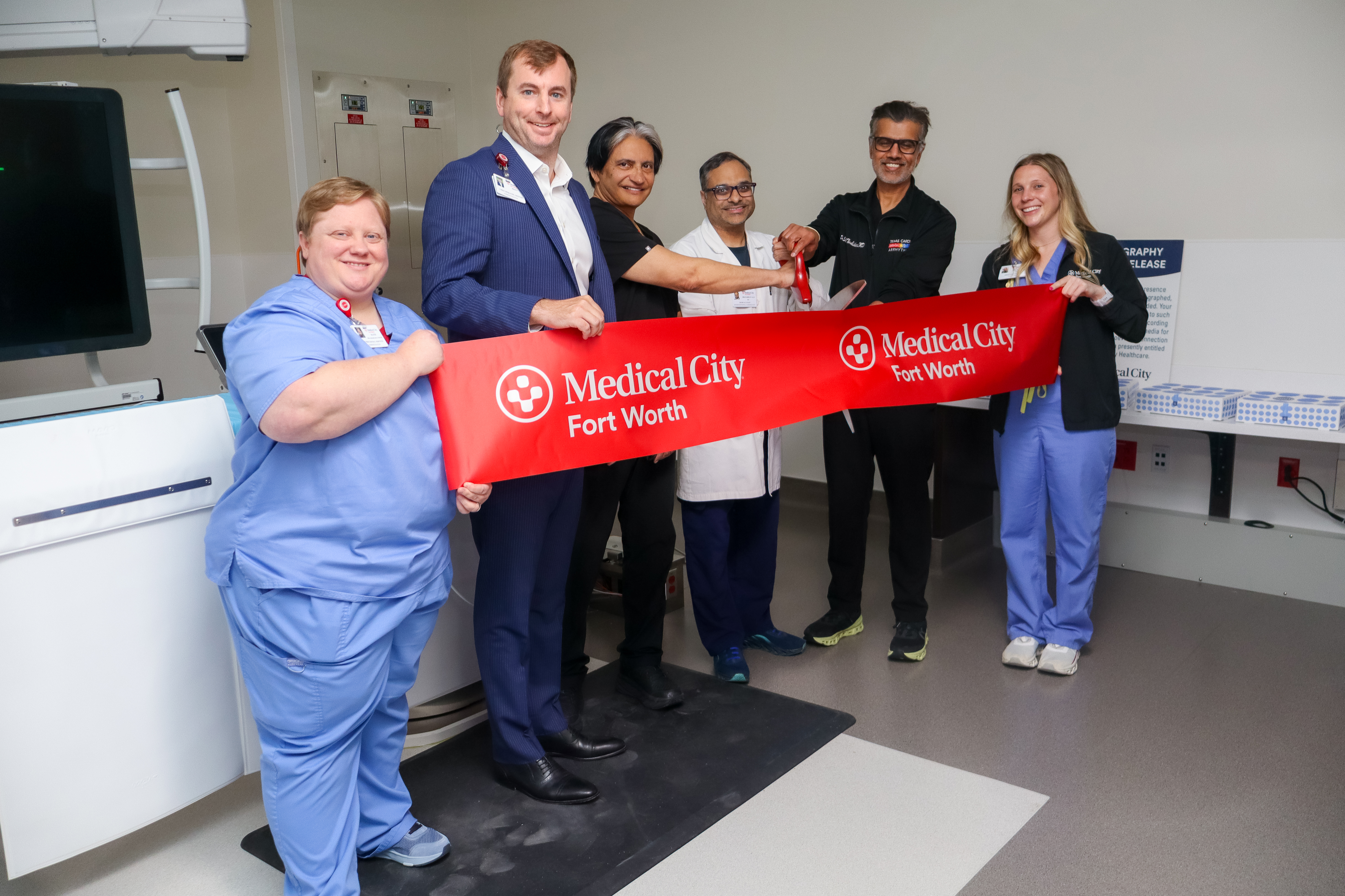 Medical City Fort Worth senior leadership team and doctors and staff cutting the ribbon to open the fifth cath lab at MCFW