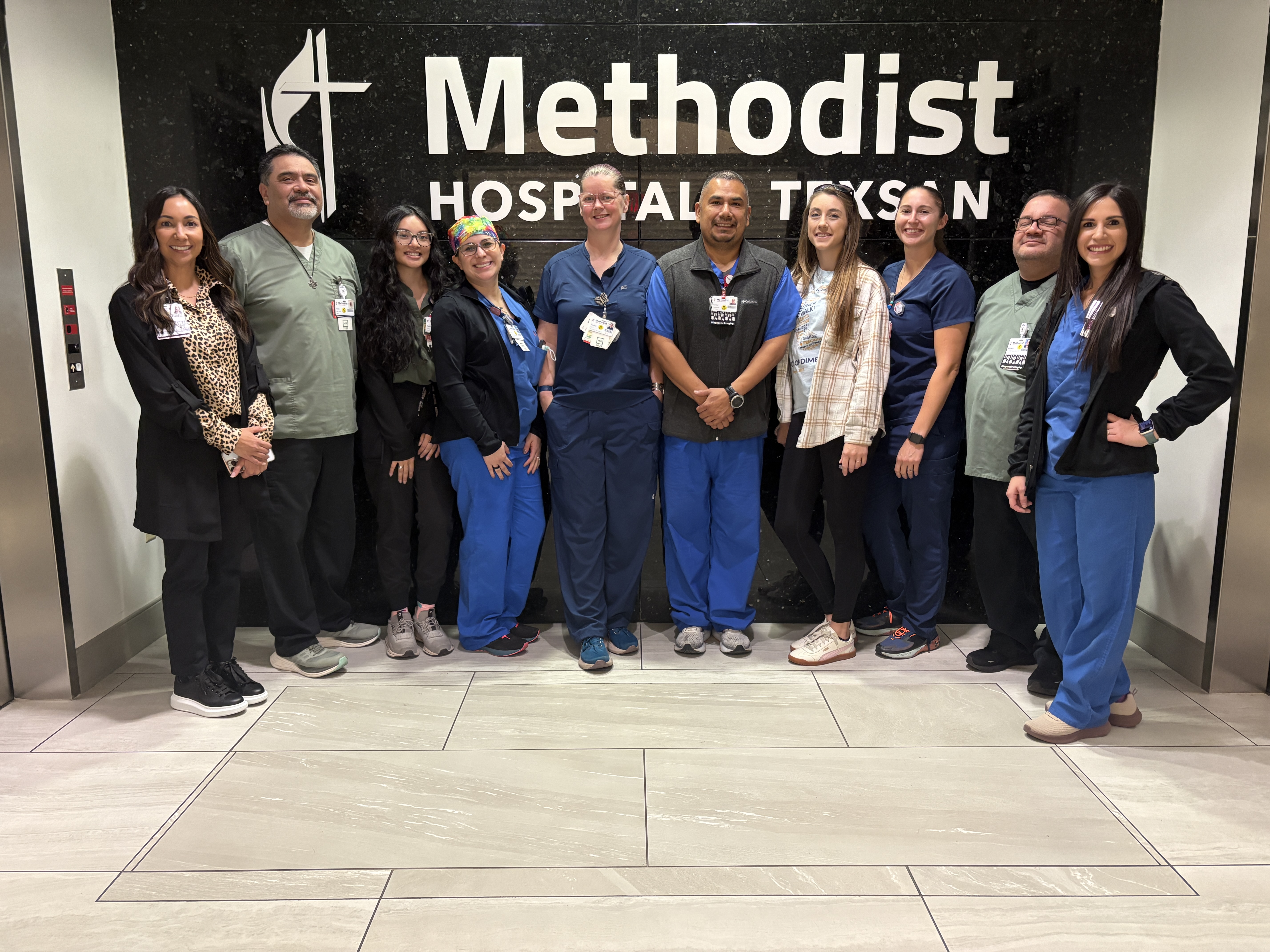 Methodist Hospital Texsan diagnostic imaging team members stand before a black wall with the hospital name in white letters.