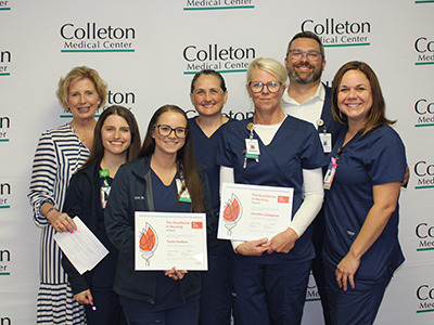 A group of nurses holding their excellence awards.