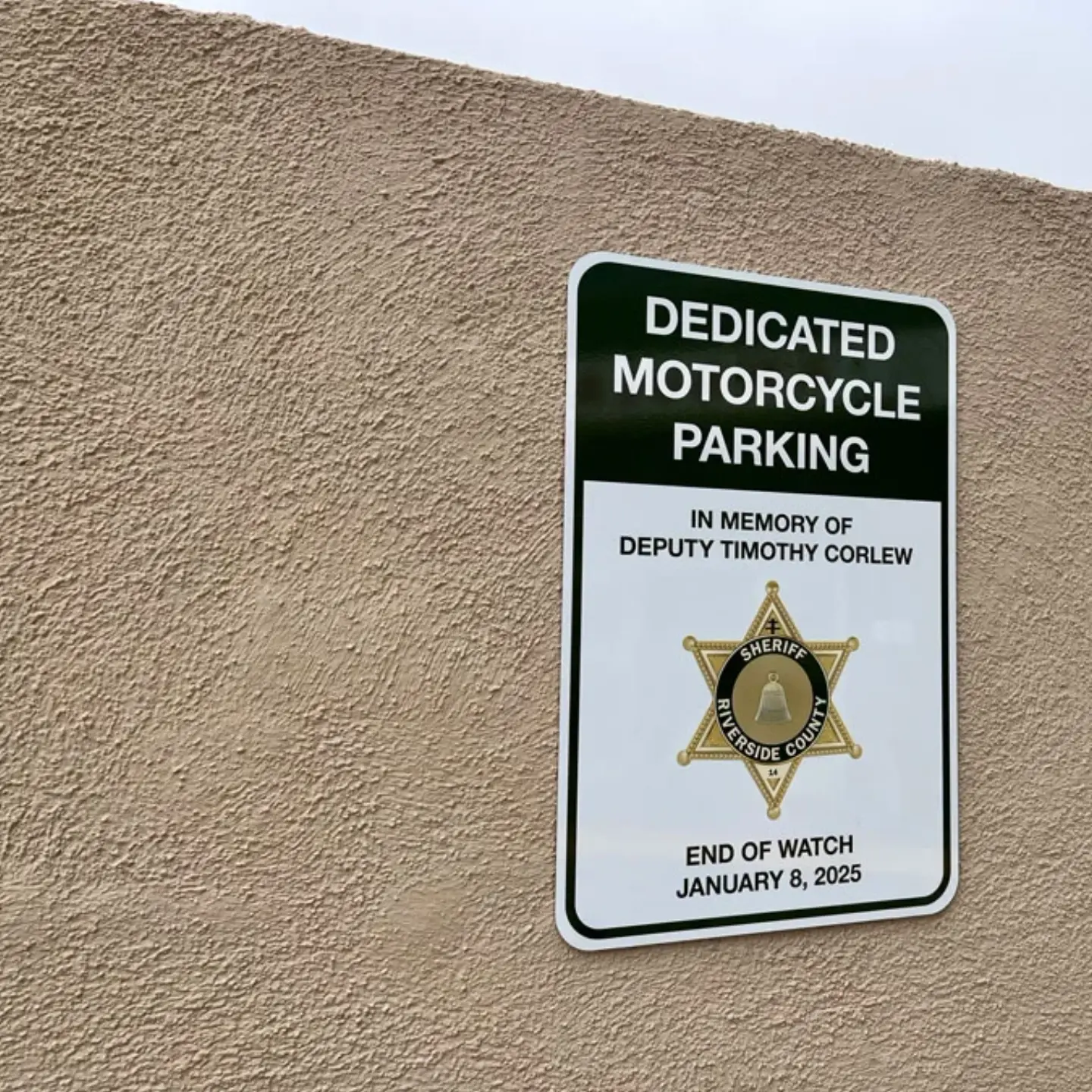 A plaque for the memory of Timothy Corlew with the words, "Dedicated Motorcycle Parking In Memory of Deputy Timothy Corlew End of Watch January 8, 2025."