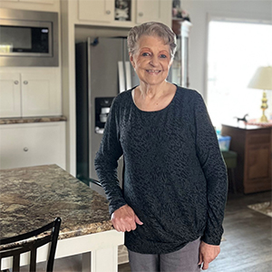 Darlene Rushton standing in her kitchen, smiling.