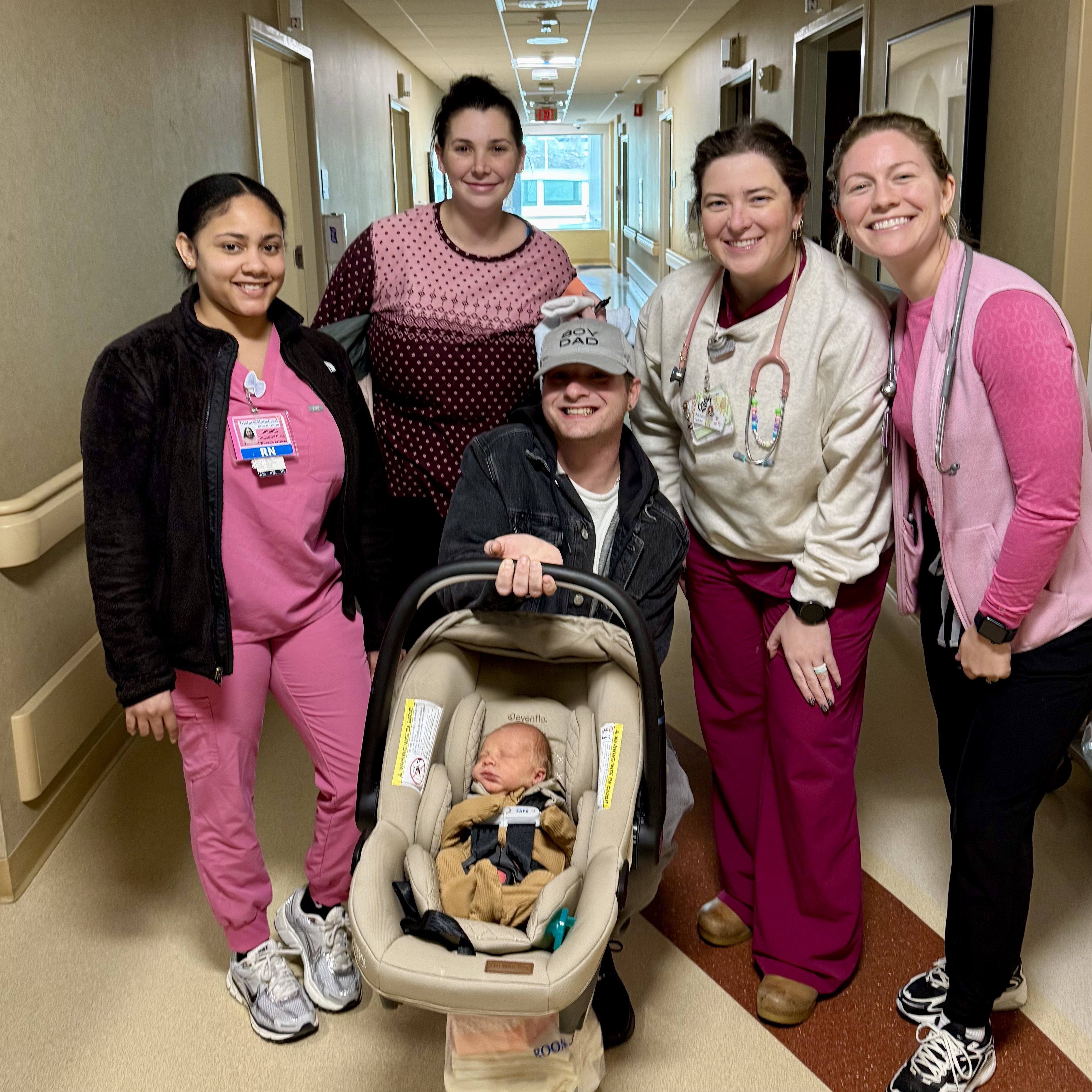 Colby and Sam and Jaxon pose for picture with StoneCrest team members in hospital hallway.
