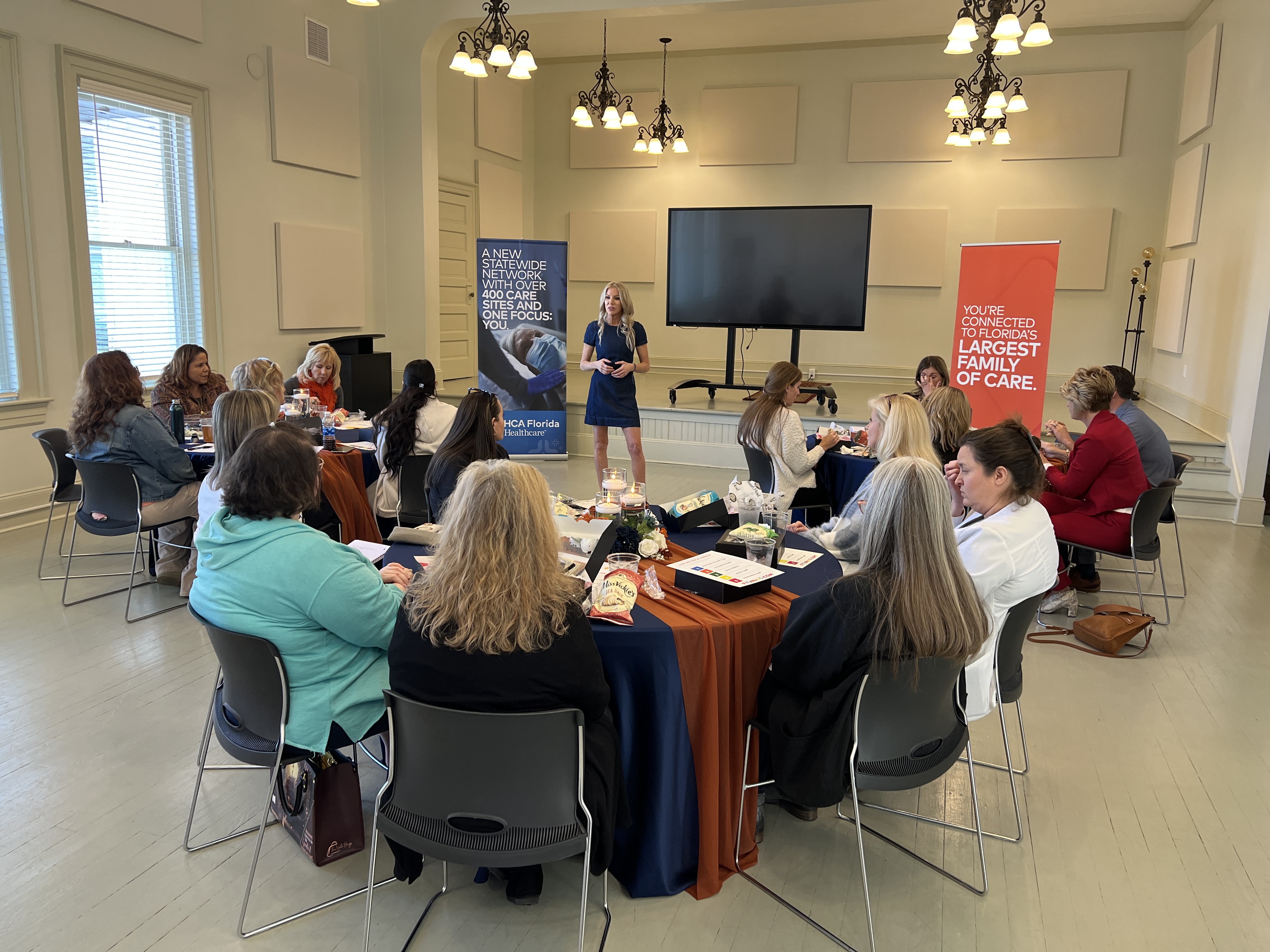 Fitz Koehler presenting to a group of women in a meeting hall.