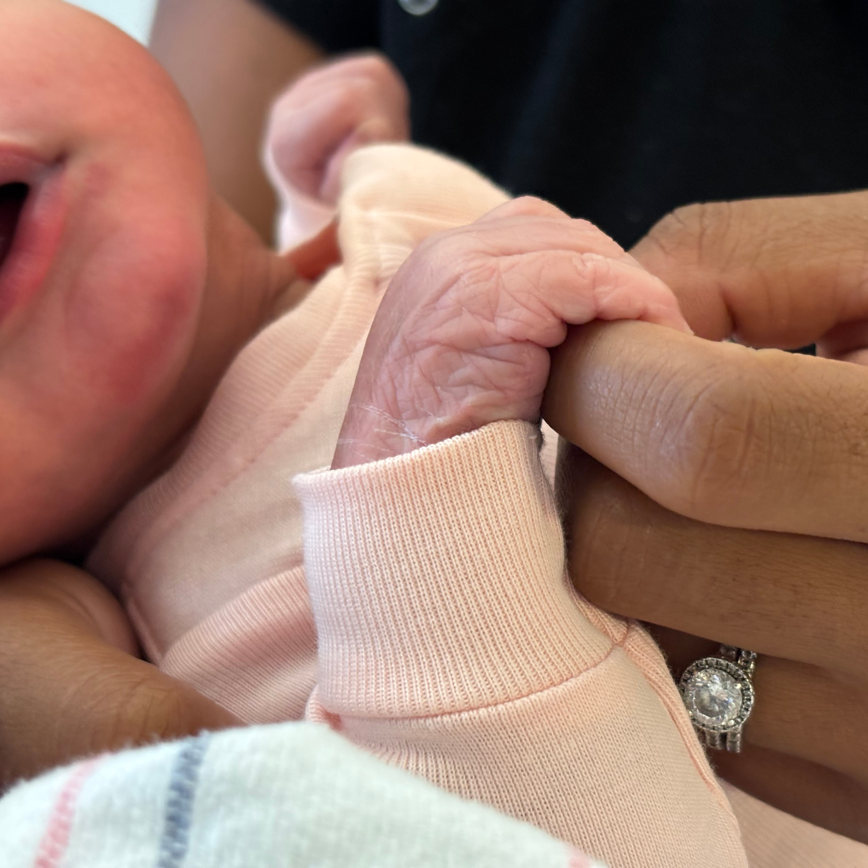 Kailan's holding her baby's tiny hand.