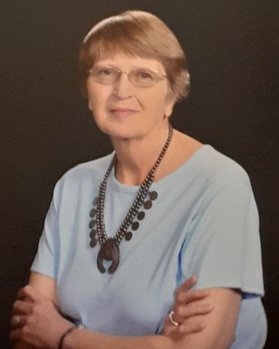 Bernice Strompoly smiles while crossing her arms for a portrait.