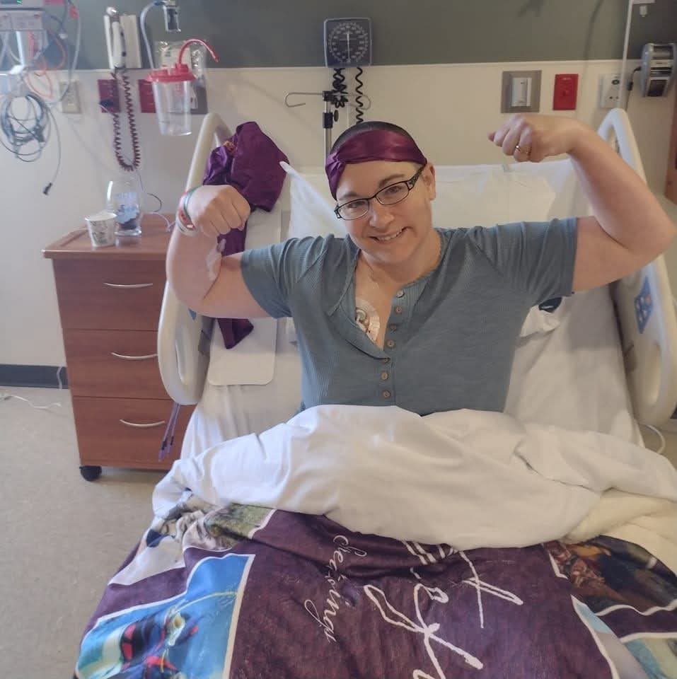 Female patient in bed-smiling and posing strength for a photo. 