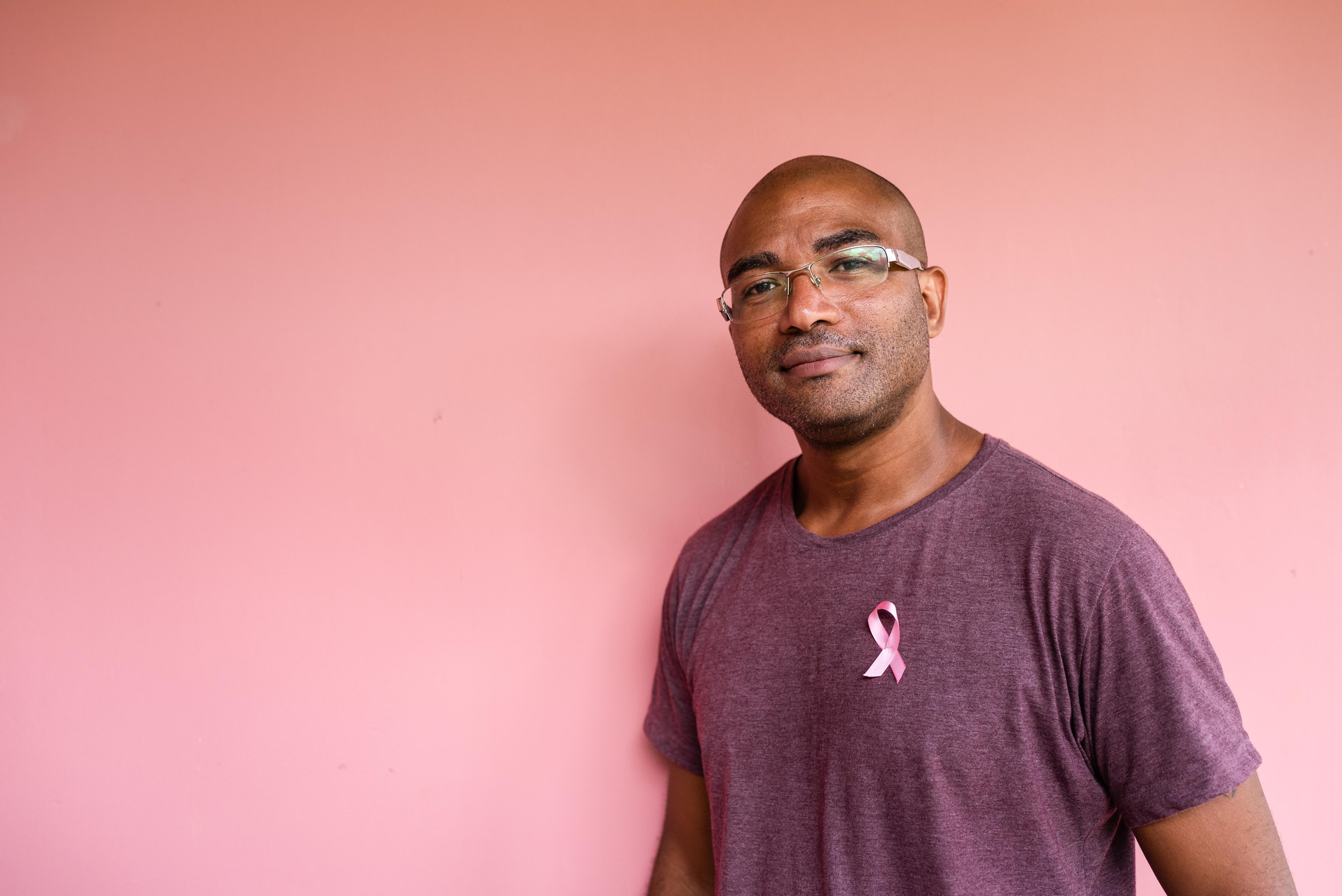 Man with pink October ribbon on shirt - stock photo