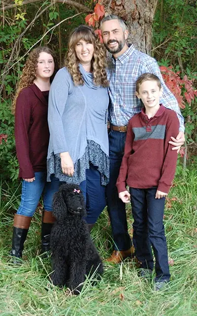 Laraine smiles and poses with her husband and children.