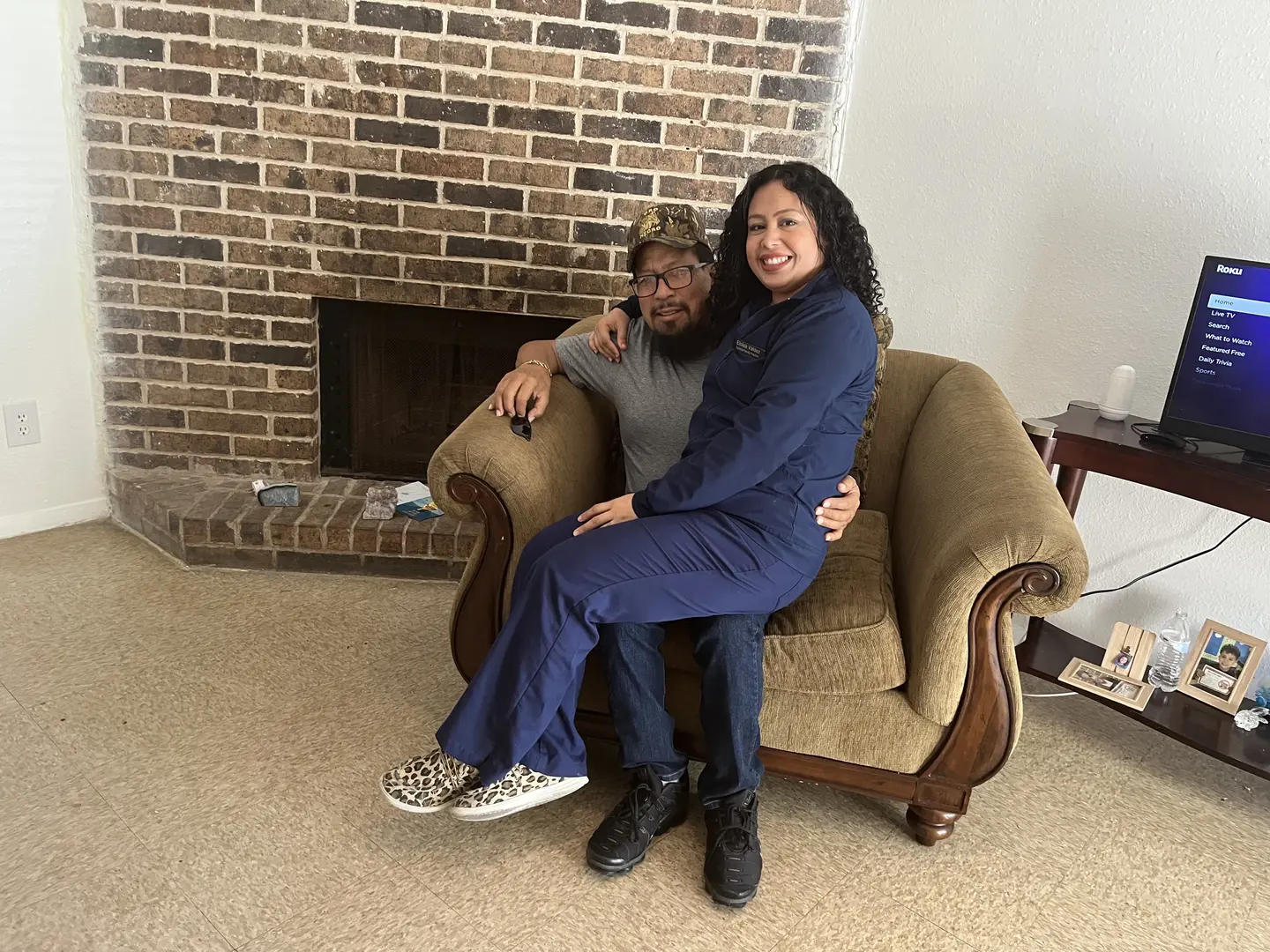 Eloisa and Adan sitting on a chair together at home
