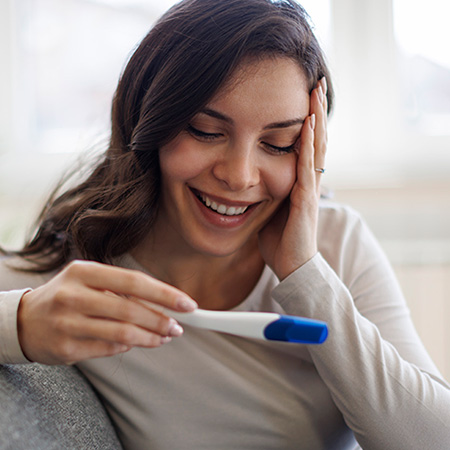 Smiling woman reading pregnancy test