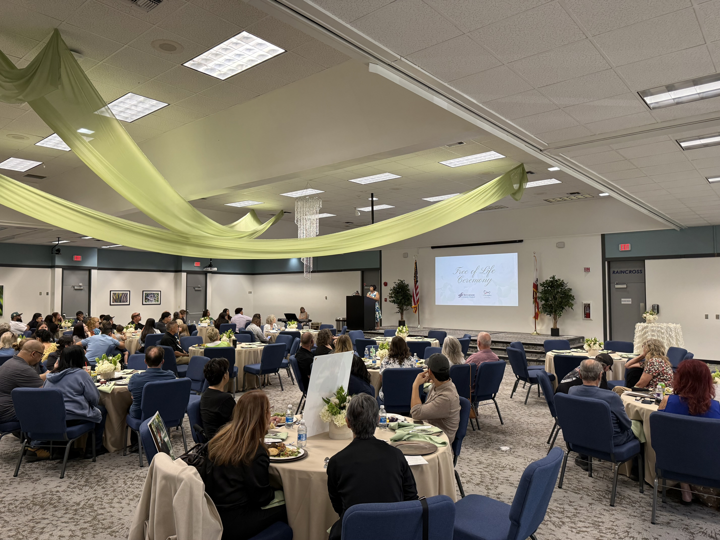 The event room showing guests listening to a speaker.