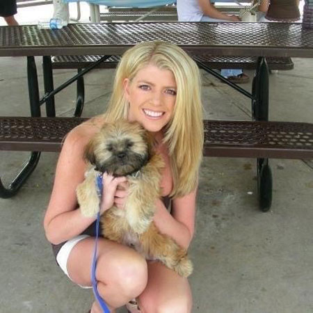 Sandy Crawford smiling as she holds her dog outside.