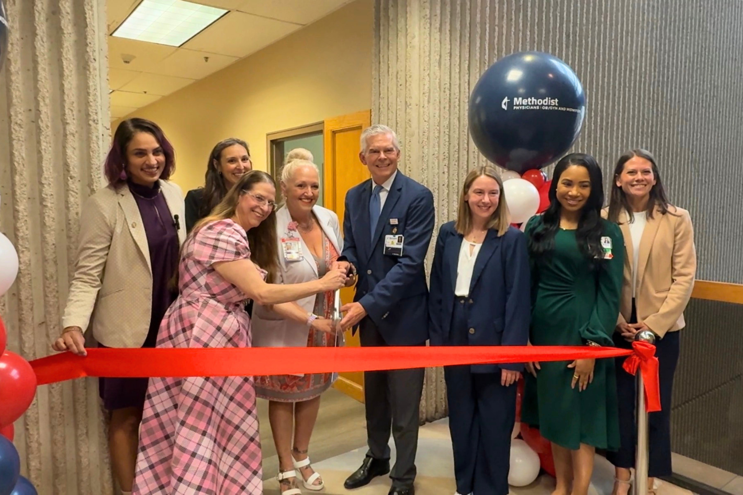 Hospital leadership team posing with physicians inside the new midwifery clinic, standing together in a bright, modern clinical space to celebrate the program's launch.