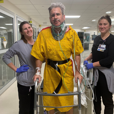 Ken walking after surgery with his care team.