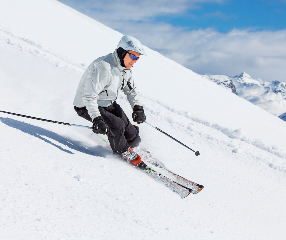 Man turning on skis on snow covered mountain.
