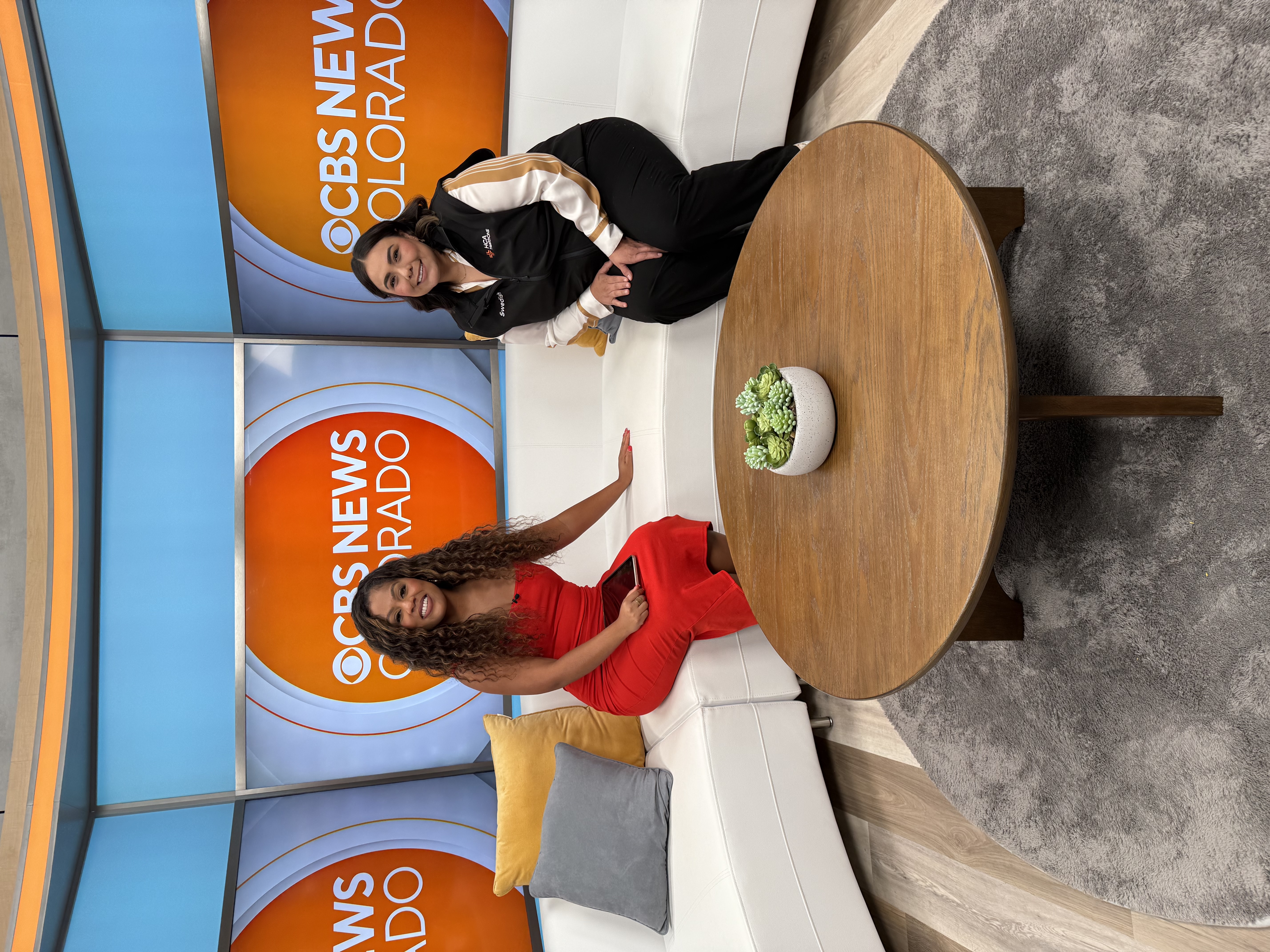 Savannah Bernal and a CBS Colorado anchor seated on a couch in the studio set