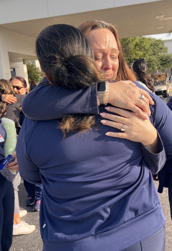 Two people embrace at the celebration nurse Tara McClintock's life.