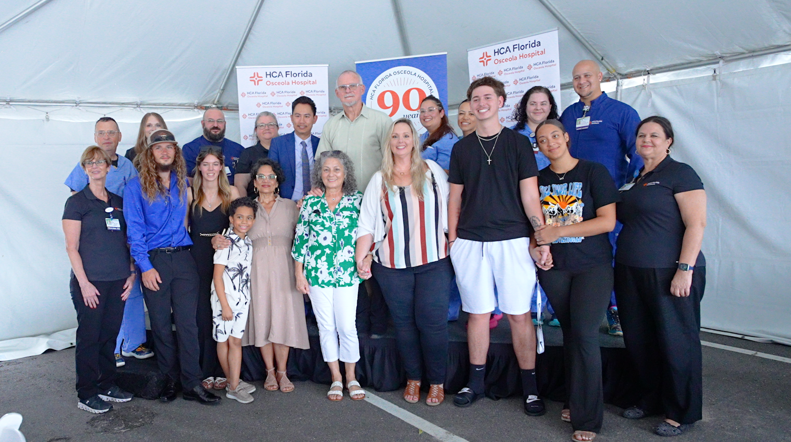 Trauma patient survivors, their families and trauma hospital team pose for a group photo.
