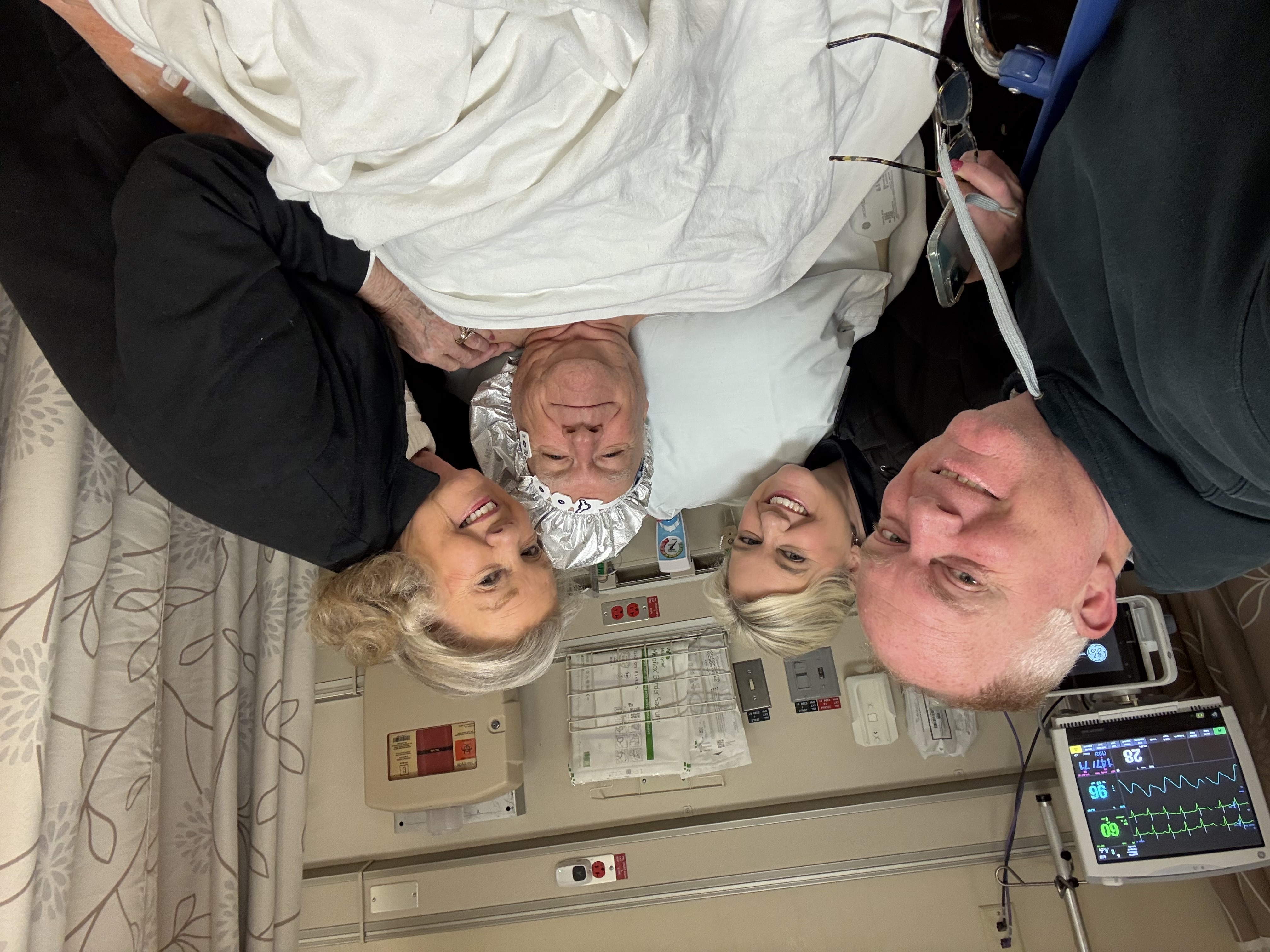 Fred Hampton surrounded by family in hospital bed