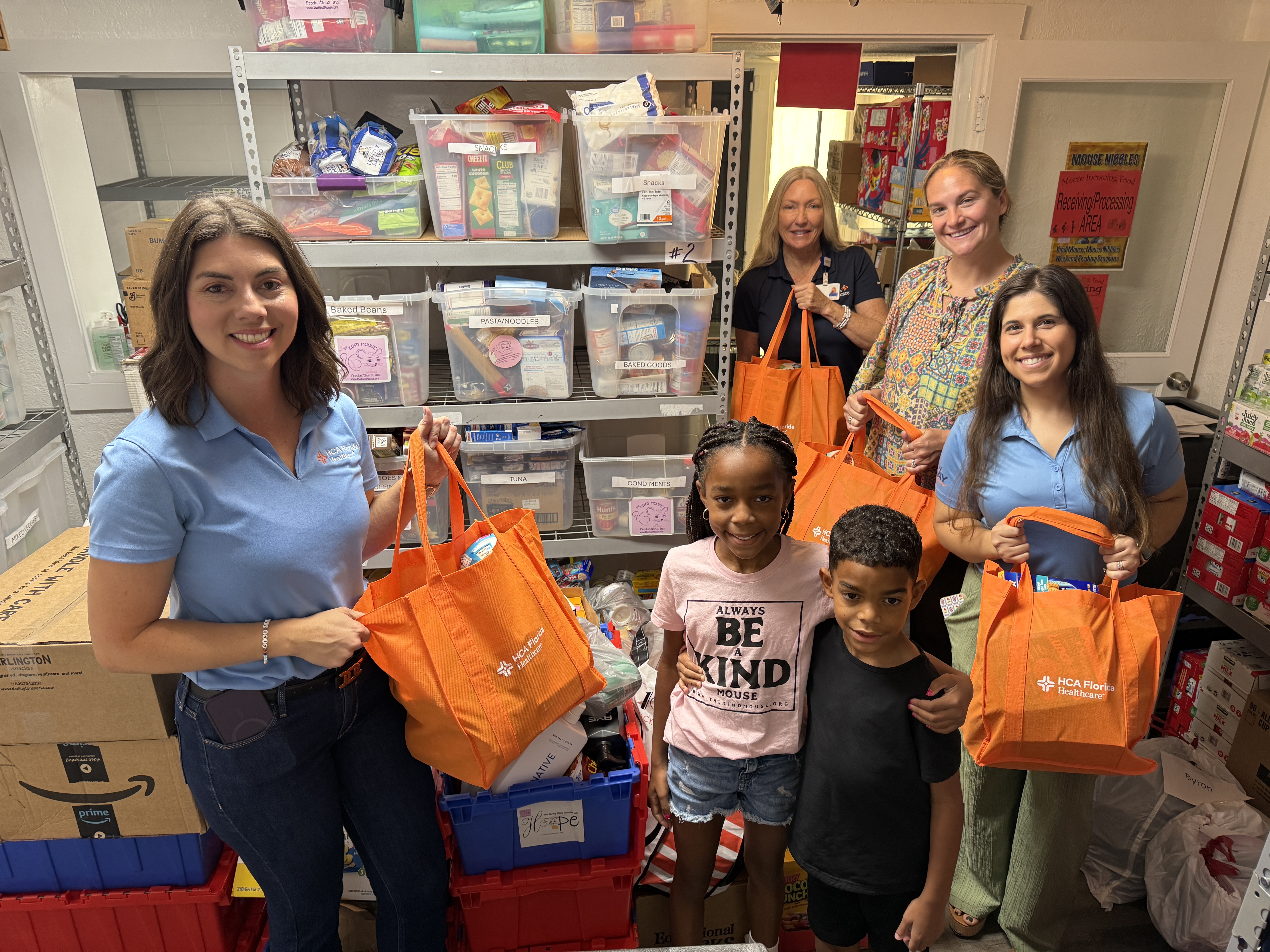 A group of volunteers and two children pose for a photo.