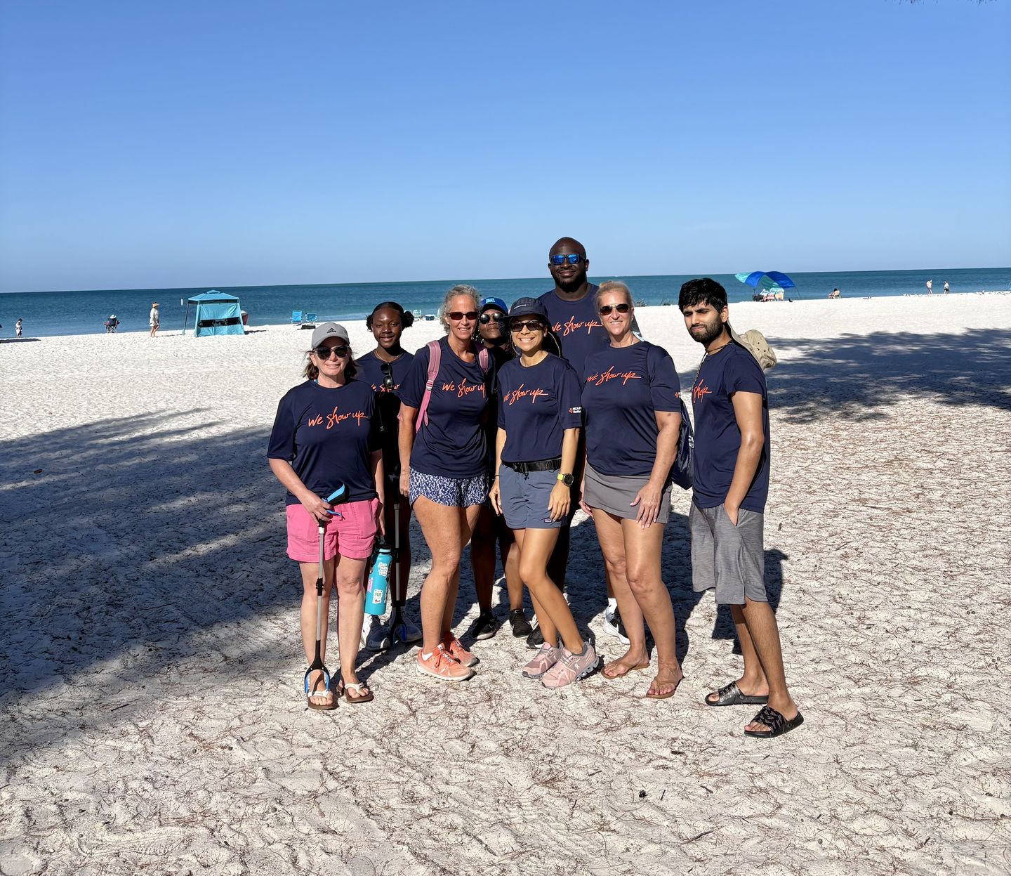 Colleagues from HCA Florida Blake Hospital pose on a Gulf Coast beach