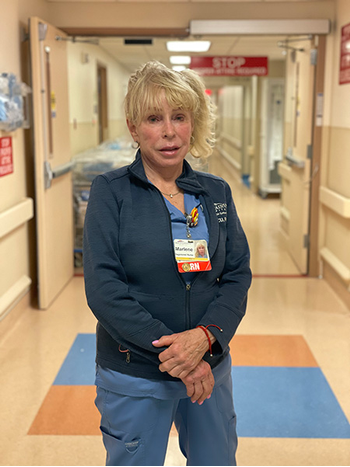 Registered Nurse, Marlene L., standing in the hospital walkway.
