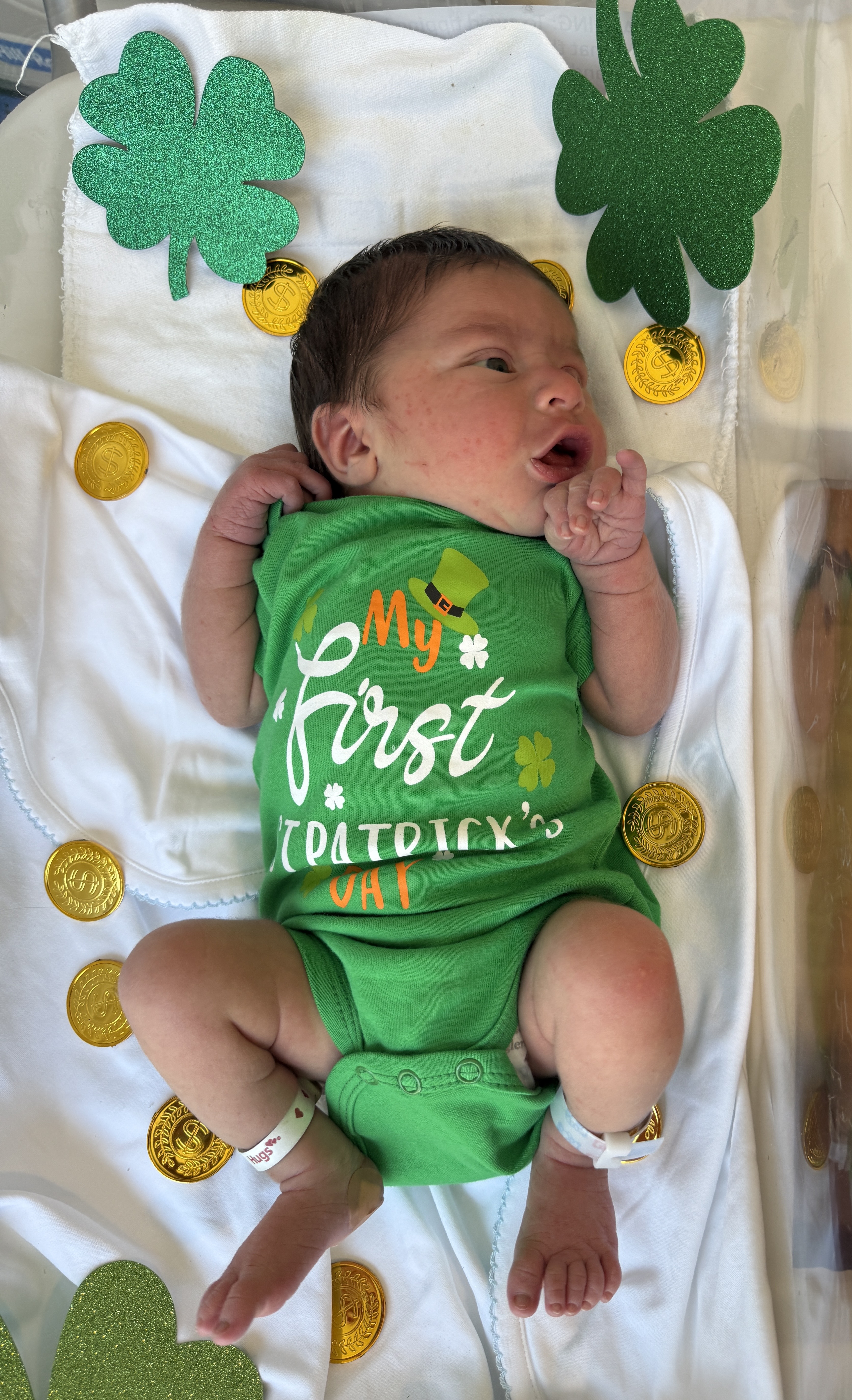 Newborn baby with St. Patricks day outfit.