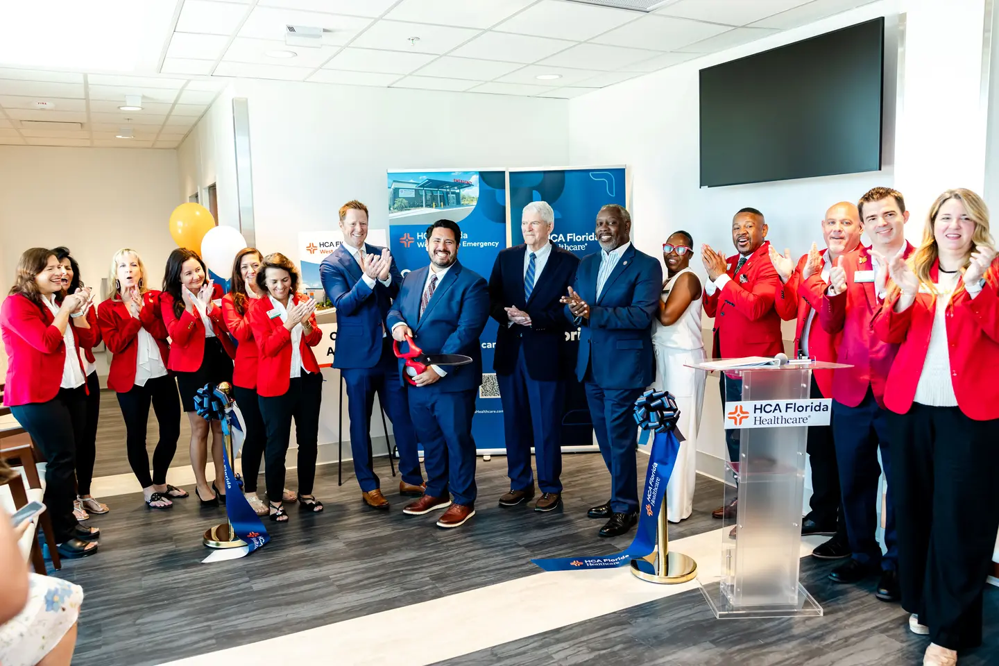 Group photo of elected officials and HCA Florida Healthcare leaders after cutting the ribbon at opening event.