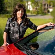 Gina posing with her red Mercedes-Benz car.