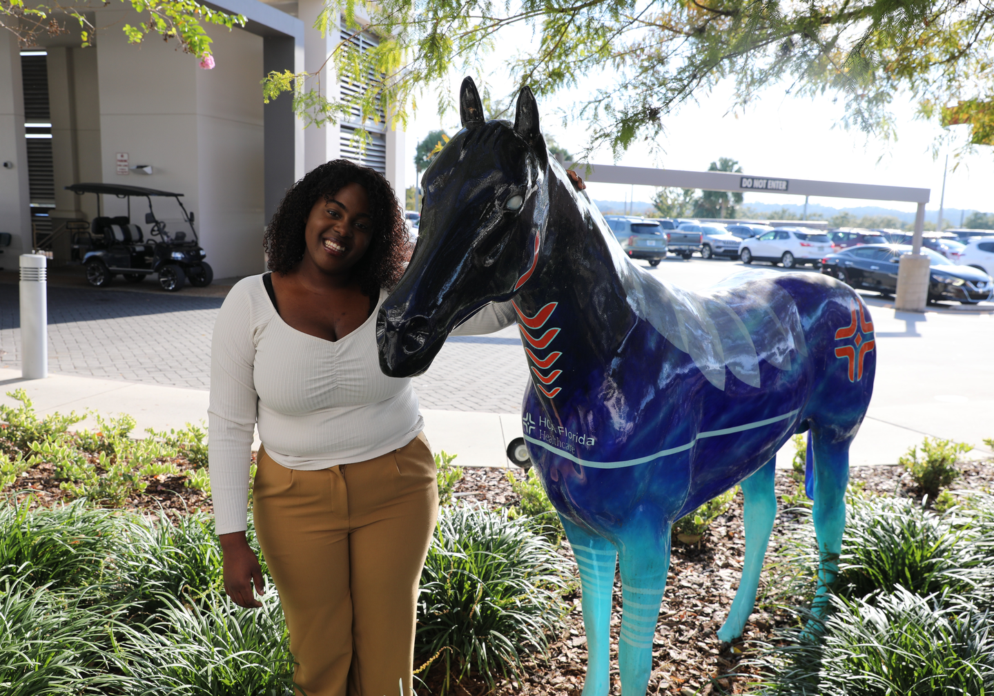 Rhiana Goode, standing next to statue.