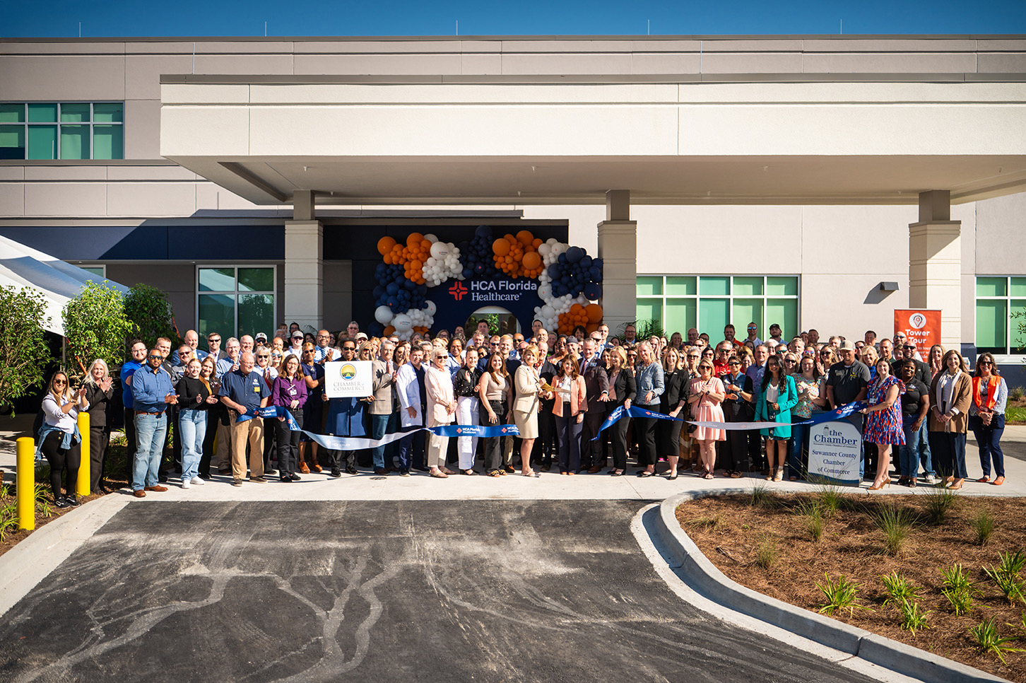 Lake City Hospital staff pose with cut blue ribbon in front of new expansion.